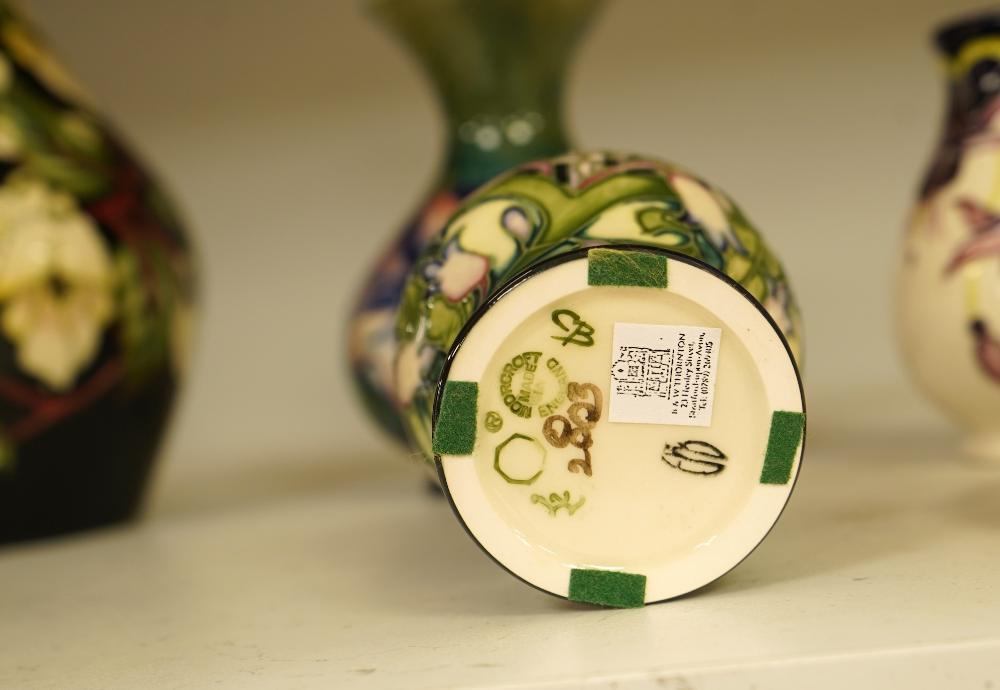 A collection of modern Moorcroft to include a mountain gold pattern vase, two pin dishes and a Hibiscus pattern candlestick, largest 20cm high